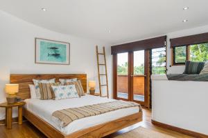 a bedroom with a large bed and a ladder at Belongil Beach House in Byron Bay