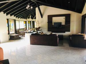 Il comprend un salon avec des canapés et une télévision à écran plat. dans l'établissement Parcelación Calima, à Calima