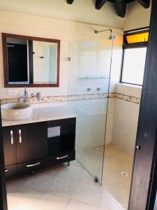 La salle de bains est pourvue d'une douche en verre et d'un lavabo. dans l'établissement Parcelación Calima, à Calima
