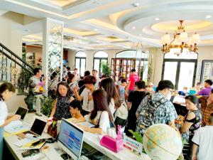 Halong Lavender Hotel في ها لونغ: زحمة الناس واقفين في غرفة بها أجهزة كمبيوتر