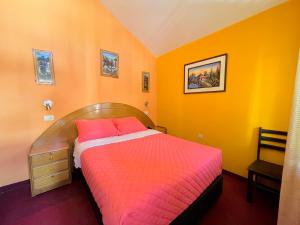 a bedroom with a bed with orange walls at Rumi Wasi in Chivay