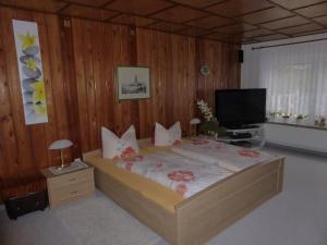 ein Schlafzimmer mit einem Bett mit rosa Blumen drauf in der Unterkunft Ferienhaus Weber Bad Frankenhausen in Bad Frankenhausen