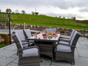 a table and chairs on a stone patio at Inverallan in Amisfield Town