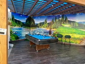 a pool table on a patio with a mural at B-7 hermoso apartamento zona de Parapentes al pie de la montaña in Jarabacoa