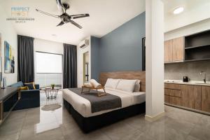 a bedroom with a king sized bed and a kitchen at Imperio Residence Seafront by Perfect Host in Malacca