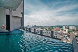 a swimming pool on the roof of a building at Imperio Residence Seafront by Perfect Host in Malacca
