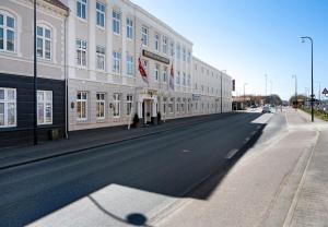 pusta ulica przed dużym budynkiem w obiekcie Hotel Postgaarden w mieście Fredericia