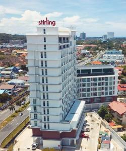a tall white building with a sign on top of it at Stirling Suites Hotel & Serviced Apartment in Miri