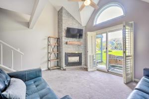 a living room with a blue couch and a fireplace at Ellicottville Townhome about Half Mi to Slopes! in Ellicottville