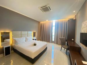 a hotel room with a bed and a television at Stirling Suites Hotel & Serviced Apartment in Miri