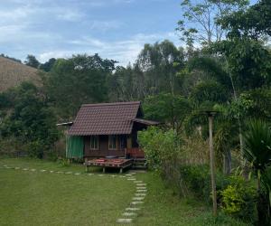 a small house with a pathway in front of it at Khaokhopimphupha farmstay เขาค้อพิมภูผาฟาร์มสเตย์ ไม่มีไฟฟ้า น้ำจากน้ำตกธรรมชาติ Low cabon with Sustainability cares in Ban Non Na Yao