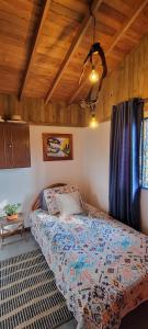 une chambre avec un lit et un plafond en bois dans l'établissement Finca El Peñol, à Guatapé