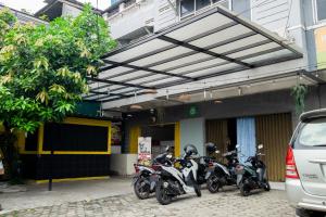 eine Gruppe von Motorrädern, die vor einem Gebäude geparkt sind in der Unterkunft Singgahsini Near MRT Haji Nawi in Jakarta