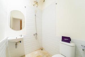 a bathroom with a toilet and a sink and a mirror at Singgahsini Near MRT Haji Nawi in Jakarta