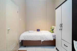 ein kleines Schlafzimmer mit einem Bett und einem Schrank in der Unterkunft Singgahsini Near MRT Haji Nawi in Jakarta
