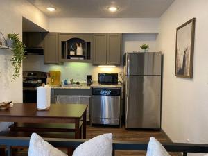 a kitchen with a stainless steel refrigerator and a table at Magnolia Suiteking Bednrgmed Center1st Floor in Houston