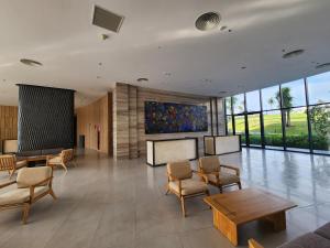 a lobby with chairs and tables and a painting on the wall at Apartment Cam Ranh in Thôn Hòa Ða