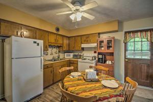 a kitchen with a table and a white refrigerator at Quaint Hinton Hideaway - Hunt and Fish Nearby! in Hinton