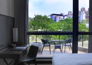 a hotel room with a bed and a desk and chairs at Platinum Hotel in Xindian