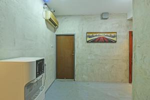 una habitación con una puerta y una televisión en ella en OYO 90662 The 1975 Hotel Empire en Kuantan