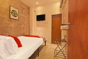 a bedroom with two beds and a tv on the wall at OYO 90662 The 1975 Hotel Empire in Kuantan