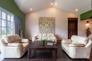 a living room with two couches and a coffee table at StayVista's Shivom Villa 12 - A Serene Escape with Views of the Valley and Lake in Lonavala +26 photos