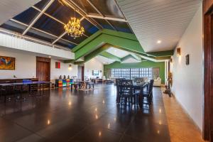 uma sala de jantar com mesas e cadeiras e um lustre em StayVista's Shivom Villa 12 - A Serene Escape with Views of the Valley and Lake em Lonavala