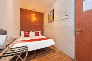 Cette petite chambre comprend un lit et une chaise. dans l'établissement OYO 90662 The 1975 Hotel Empire, à Kuantan