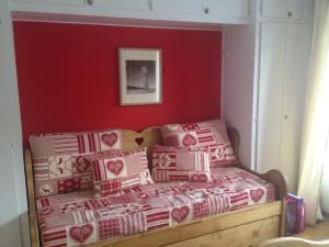 a couch in a room with a red wall at Alpe Blanche in Crans-Montana