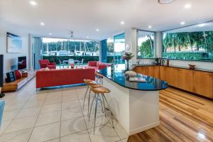 漢密爾頓島的住宿－Pavillions 1 - NEW Waterside Luxury with pool，开放式厨房和带红色沙发的客厅
