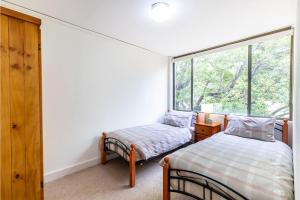 a bedroom with two beds and a window at Harbourside 15 right on the waterfront in Soldiers Point