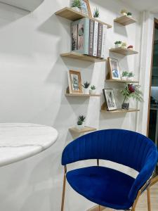 einem blauen Stuhl vor einer Wand mit Regalen in der Unterkunft 88 Living in Bangkok
