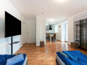 a living room with a couch and a flat screen tv at Lovely Holiday Home in Haunsheim in Haunsheim