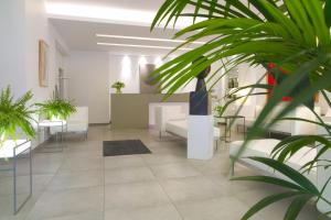 a lobby with tables and chairs and plants at Hotel Simoncini in Luxembourg