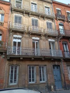 - un bâtiment avec des balcons sur le côté dans l'établissement Confortable T2 à Saint Aubin, à Toulouse