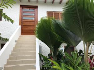 a staircase leading to a house with a wooden door at Vacaciones Playa Club Casa Blanca Same Esmeraldas in Same
