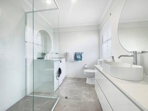 a bathroom with a sink and a toilet and a mirror at Studio Seaside Self-contained apartment in Marcoola