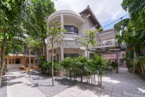 a building with trees in front of it at M Village Lý Chính Thắng in Ho Chi Minh City