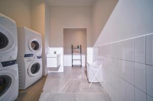 a white laundry room with a washer and dryer at M Village Lý Chính Thắng in Ho Chi Minh City