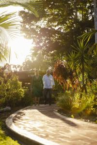 two people walking down a path in a garden at Ferns Hideaway Resort in Byfield