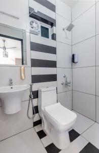 a bathroom with a white toilet and a sink at Dune Homestay in Alleppey