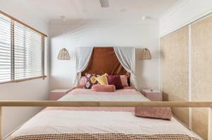 a bedroom with a large bed with pink pillows at Midnights in Morocco in Brisbane