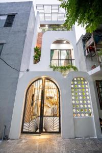 a white building with a door with a window at Gạo House Homestay Đà Nẵng gần sân bay và trung tâm thành phố in Danang