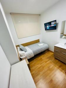 Dormitorio pequeño con cama y lavamanos en HOSPEDAJE COLONIA VALLECAS, en Madrid