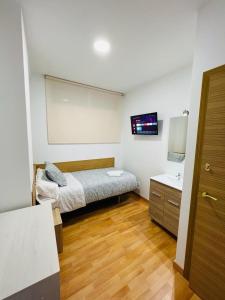 a small bedroom with a bed and a sink at HOSPEDAJE COLONIA VALLECAS in Madrid