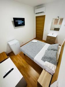 Dormitorio pequeño con cama y TV en HOSPEDAJE COLONIA VALLECAS, en Madrid