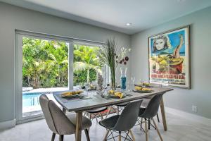 a dining room with a table with chairs and a large window at Modern Wilton Manors Home with Outdoor Oasis! in Fort Lauderdale