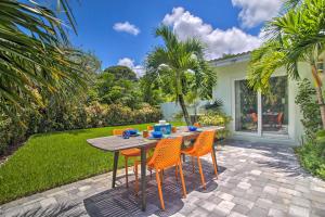 einen Holztisch und Stühle auf einer Terrasse in der Unterkunft Modern Wilton Manors Home with Outdoor Oasis! in Fort Lauderdale