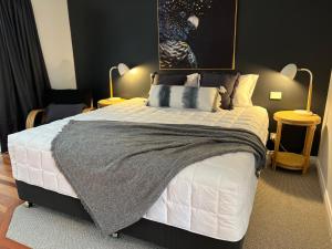 una camera da letto con un grande letto bianco con due lampade di The Arabella North Coast a Wollongbar