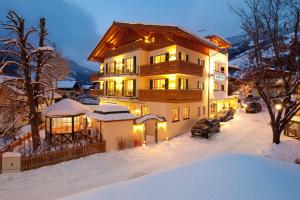 Una casa en la nieve por la noche con luces en Landhotel Römerhof en Dorfgastein